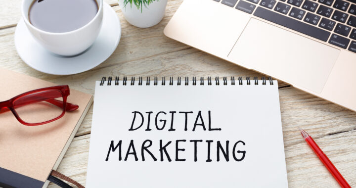 Digital marketing handwriting note with laptop pen and coffee cup on office desk
