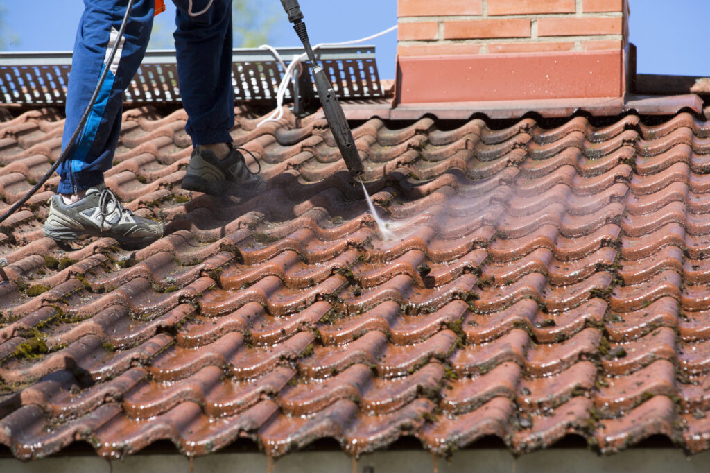 Washing the roof with a high pressure water washer.